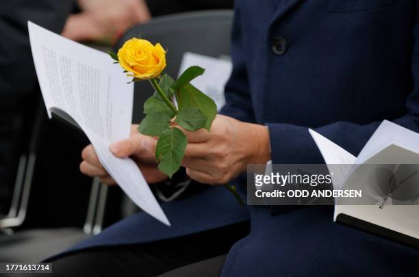 Crown Prince Haakon of Norway holds a rose as he attends a commemoration for the 34th anniversary of the fall of the Berlin Wall at the the Berlin...
