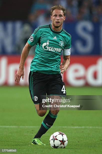 Benedikt Hoewedes of Schalke runs with the ball during the UEFA Champions League Play-off first leg match between FC Schalke 04 and PAOK Saloniki at...