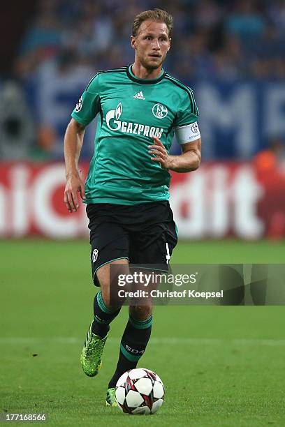 Benedikt Hoewedes of Schalke runs with the ball during the UEFA Champions League Play-off first leg match between FC Schalke 04 and PAOK Saloniki at...