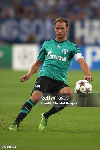 Benedikt Hoewedes of Schalke runs with the ball during the UEFA Champions League Play-off first leg match between FC Schalke 04 and PAOK Saloniki at...