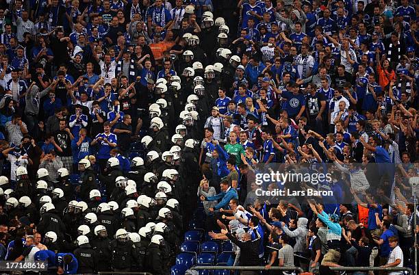 Riot police clash with fans of Schalke during the UEFA Champions League Play-off first leg match between FC Schalke 04 and PAOK Saloniki at...