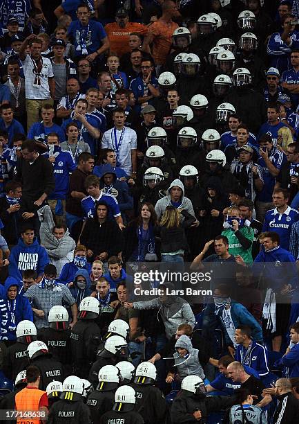 Riot police clash with fans of Schalke during the UEFA Champions League Play-off first leg match between FC Schalke 04 and PAOK Saloniki at...