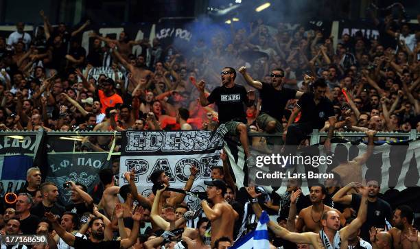 Fans of Saloniki celebrate during the UEFA Champions League Play-off first leg match between FC Schalke 04 and PAOK Saloniki at Veltins-Arena on...