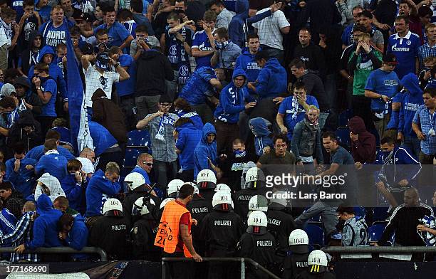 Riot police clash with fans of Schalke during the UEFA Champions League Play-off first leg match between FC Schalke 04 and PAOK Saloniki at...