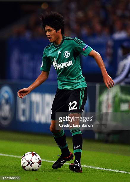 Atsuto Uchida of Schalke runs with the ball during the UEFA Champions League Play-off first leg match between FC Schalke 04 and PAOK Saloniki at...