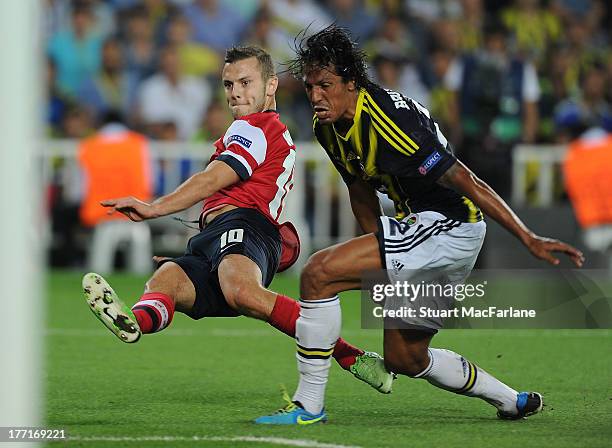 Jack Wilshere of Arsenal breaks past Bruno Alves of Fenerbahce during the UEFA Champions League Play Off first leg match between Fenerbache SK and...