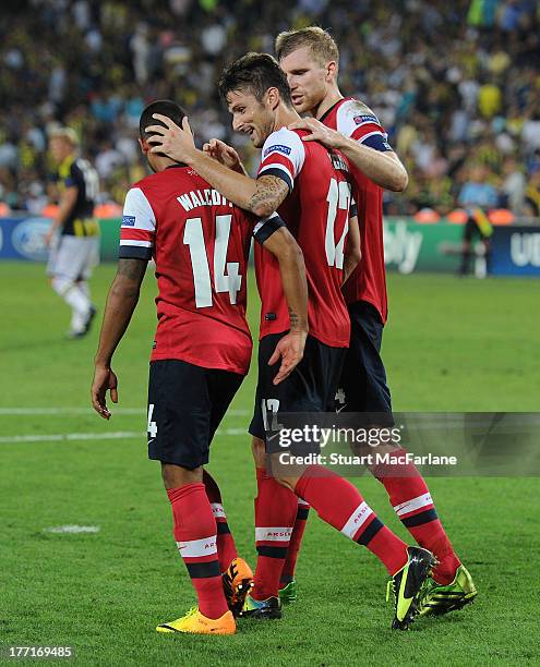 Olivier GIroud celebrates scoring the 3rd Arsenal goal with Theo Walcott and Per Mertesacker during the UEFA Champions League Play Off first leg...