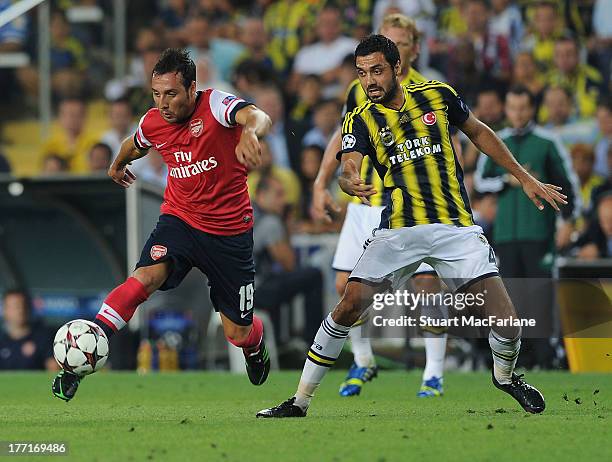 Santi Cazorla of Arsenal breaks past Bekir Irtgun of Fenerbache during the UEFA Champions League Play Off first leg match between Fenerbache SK and...