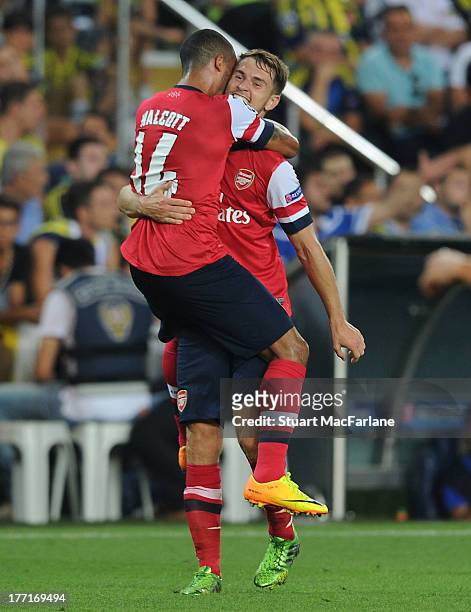 Aaron Ramsey celebrates scoring the 3rd Arsenal goal with Theo Walcott during the UEFA Champions League Play Off first leg match between Fenerbache...