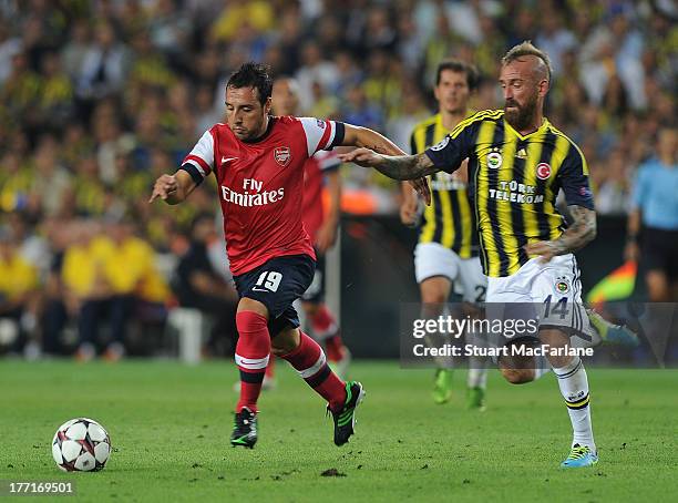 Santi Cazorla of Arsenal breaks past Raul Meireles of Fenerbache during the UEFA Champions League Play Off first leg match between Fenerbache SK and...