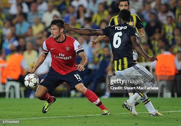 Olivier Giroud of Arsenal breaks past Joseph Yobo during the UEFA Champions League Play Off first leg match between Fenerbache SK and Arsenal FC at...