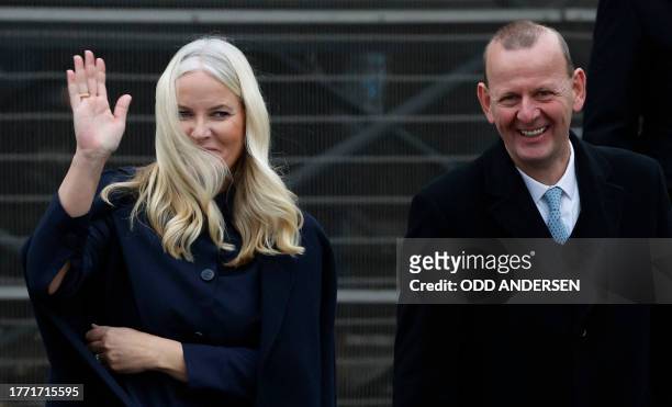 Crown Princess Mette-Marit of Norway waves next to Axel Klausmeier, director of the Berlin Wall Foundation, as she leaves after attending festivities...