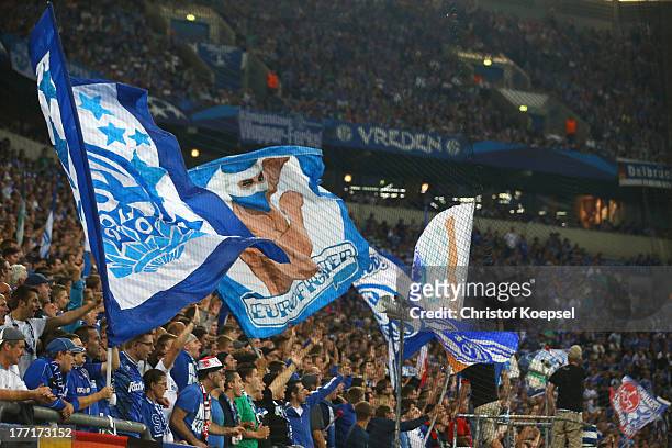 Fans of Schalke wave flags during the UEFA Champions League Play-off first leg match between FC Schalke 04 and PAOK Saloniki at Veltins-Arena on...