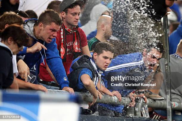 Fans of Schalke throw water at policemen during the UEFA Champions League Play-off first leg match between FC Schalke 04 and PAOK Saloniki at...