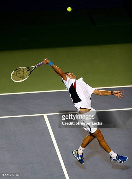 Tommy Robredo of Spain returns a shot against Gael Monfils of France during day 4 of the Winston-Salem Open at Wake Forest University on August 21,...