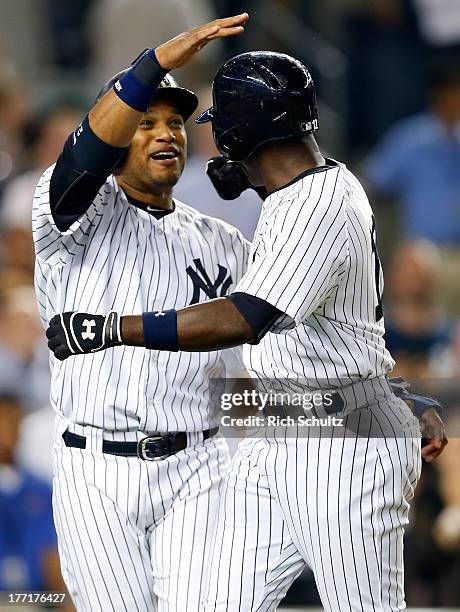 Alfonso Soriano of the New York Yankees is congratulated by teammate Robinson Cano after Soriano hit a two-run home run in the eighth inning breaking...