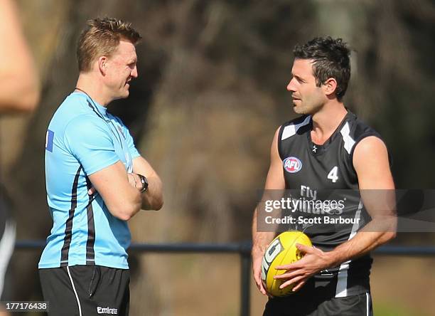 Alan Didak of the Magpies talks with Magpies coach Nathan Buckley during a Collingwood Magpies AFL training session at Olympic Park on August 22,...