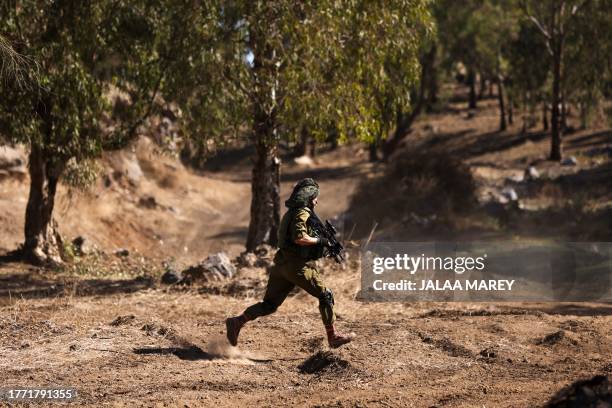 An Israeli soldier runs to a position during a drill in the annexed Golan Heights on November 9 amid increasing cross-border tensions between...