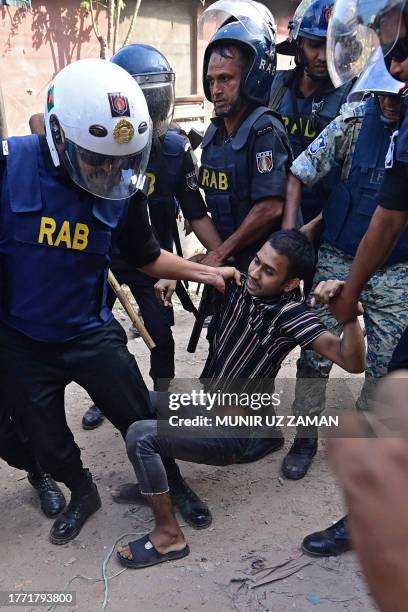 Rapid Action Battalion personnel detain a garment worker during a protest in Gazipur on November 9, 2023. Up to 25,000 garment workers clashed with...