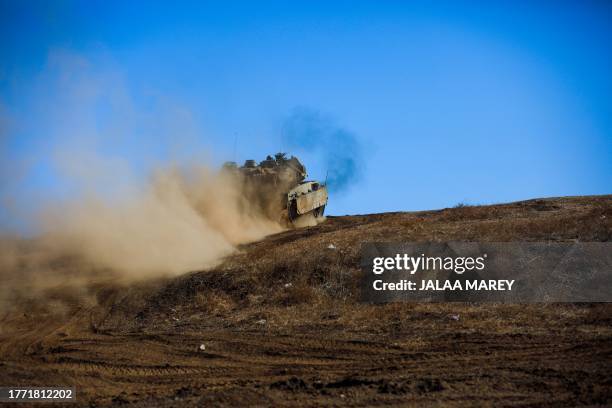 An Israeli military tank moves to a position during a drill in the annexed Golan Heights on November 9 amid increasing cross-border tensions between...