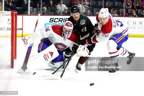 Barrett Hayton of the Arizona Coyotes attacks the net for a loose puck against goaltender Jake Allen and Juraj Slafkovsky of the Montreal Canadiens...