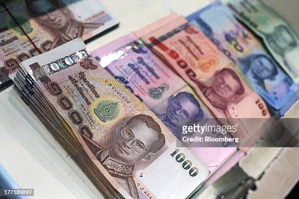 Thai baht banknotes of various denominations sit inside a drawer for an arranged photograph at a Super Rich 1965 Co. Currency exchange store in...