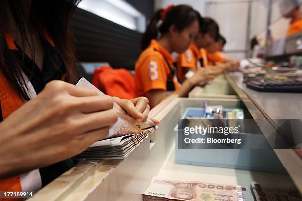 An employee counts Thai one-thousand baht banknotes at a Super Rich 1965 Co. Currency exchange store in Bangkok, Thailand, on Thursday, Aug. 22,...
