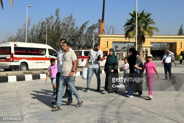 Passengers cross into Egypt's Rafah border crossing with the Gaza Strip, on November 9 amid the ongoing battles between Israel and the Palestinian...