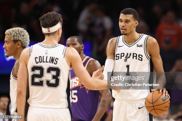Victor Wembanyama of the San Antonio Spurs celebrates with Zach Collins following the NBA game against the Phoenix Suns at Footprint Center on...