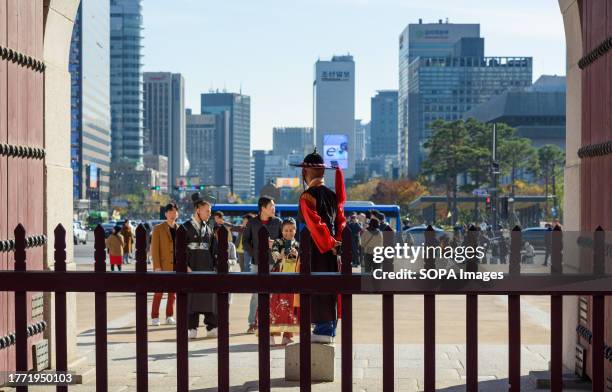 Tourists wearing Hanbok, Korea's traditional costume, take commemorative photos at Gwanghwamun, the main gate of Gyeongbokgung Palace in Seoul....