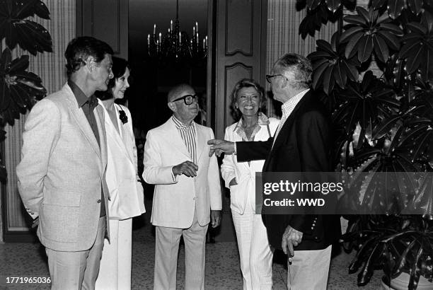 Louis Jourdan, Audrey Wilder, Irving "Swifty" Lazar, Berthe Jourdan, and Billy Wilder attend a party at the Lazar residence in Los Angeles,...