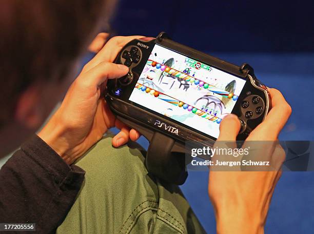 Gaming enthusiast tries out a Sony Playstation Vita game at the Gamescom 2013 gaming trade air on August 22, 2013 in Cologne, Germany. Gamescom is...