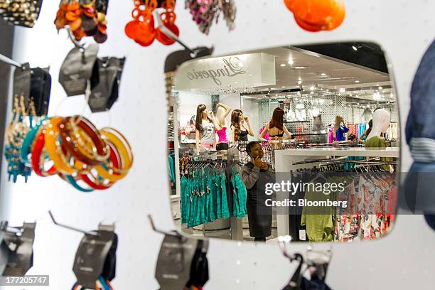 Displays of fashion clothing is reflected in a mirror inside a Truworths International Ltd. Store, South Africa's largest listed clothing retailer,...