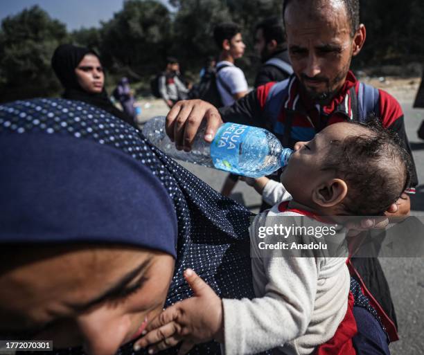 Man gives water to Palestinian child who leave with his mother from the northern part of the Gaza to flee the central and southern parts of the Gaza...