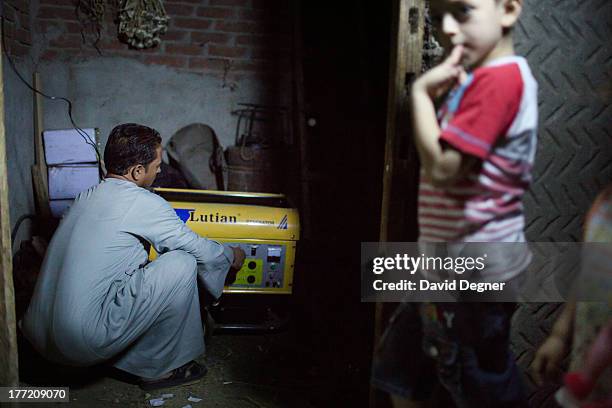 Christian farmer connects a generator to power his house after the electricity was cut in Minya, Egypt on June 12, 2013.