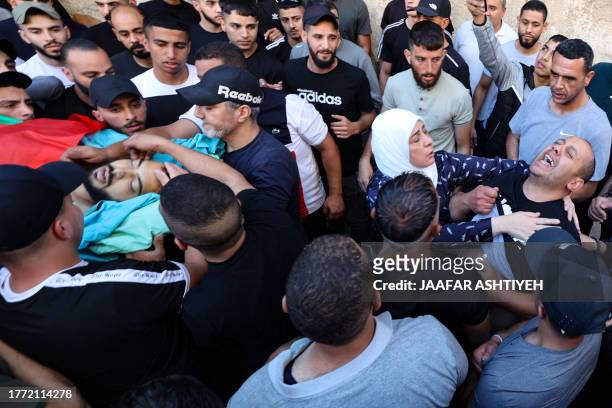 Graphic content / The father of Muhnad Abed al-Haq reacts as mourners carry his body during his funeral in Ramallah, after he was reportedly shot by...