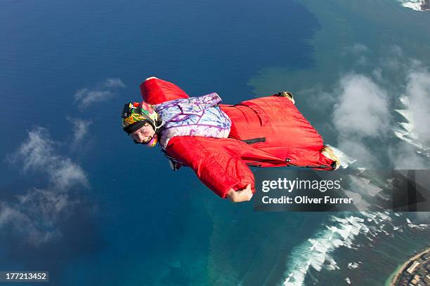 skydiver is flying within a wingsuit over clouds - wing suit stock pictures, royalty-free photos & images