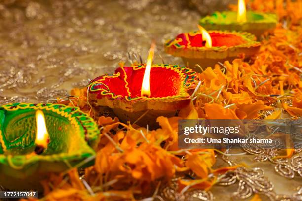 colorful clay diya oil lamps lit during diwali celebration. - diwali stock pictures, royalty-free photos & images