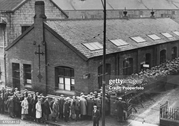 Unemployed men queuing outside the employment exchange in Clydebank, Scotland, 1st January 1932. Unemployment in the area has increased after work on...