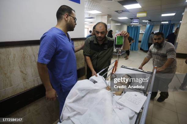 Injured Palestinians, including children, are taken to the Al-Aqsa Martyrs Hospital as Israeli attacks continue on the 34th day in Deir al-Balah,...