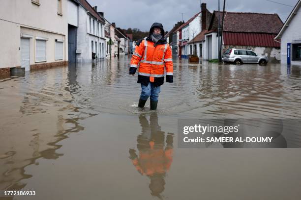An inhabitant walks in a flooded street of Neuville-sous-Montreuil, northern France, on November 9, 2023. The Pas-de-Calais region was once again hit...