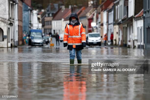 An inhabitant walks in a flooded street of Neuville-sous-Montreuil, northern France, on November 9, 2023. The Pas-de-Calais region was once again hit...