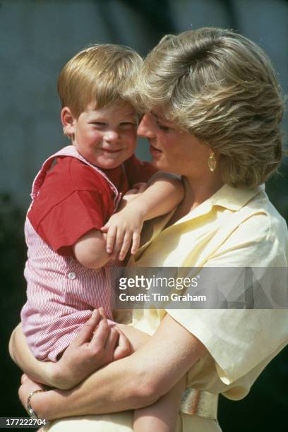 Diana, Princess Of Wales carrying her son, Prince Harry, at a photocall during their summer holiday at the Spanish Royal Palace of La Almudaina, just...