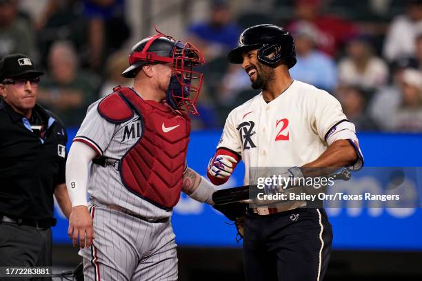 Marcus Semien of the Texas Rangers laughs with Christian Vázquez of the Minnesota Twins during a game at Globe Life Field on September 01, 2023 in...