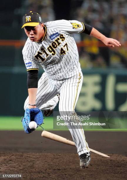 Takuma Kirishiki of the Hanshin Tigers is hit by a broken bat while trying to field a grounder in the 7th inning against Orix Buffaloes during the...