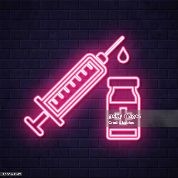 vaccination - syringe and vaccine vial. glowing neon icon on brick wall background - controlled substances covid 19 stock illustrations