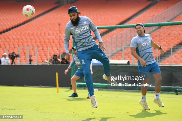 Adil Rashid of England plays football with fielding coach Carl Hopkinson ahead of a nets session at Narendra Modi Stadium on November 03, 2023 in...