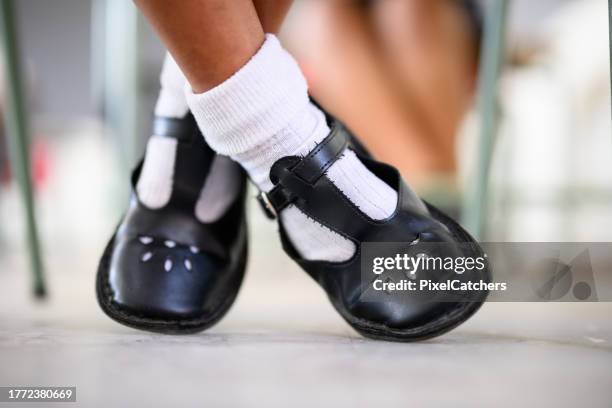 close up shiny neat girls school shoes, feet crossed under chair back to school - school socks stock pictures, royalty-free photos & images