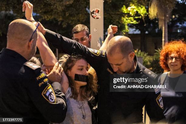 Israeli policemen detain a demonstrator that was participating in a vigil against the earlier arrests of some of leaders of the Arab-Israeli...