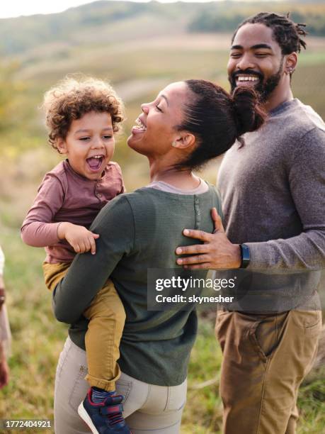 familia negra feliz disfrutando en un día de otoño en la naturaleza. - familia de verdad fotografías e imágenes de stock